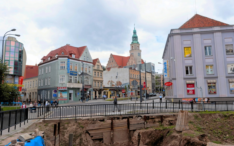 Street view of Olsztyn, a historic city in northern Poland, featuring the distinctive green tower of the Co-Cathedral of St. James the Apostle